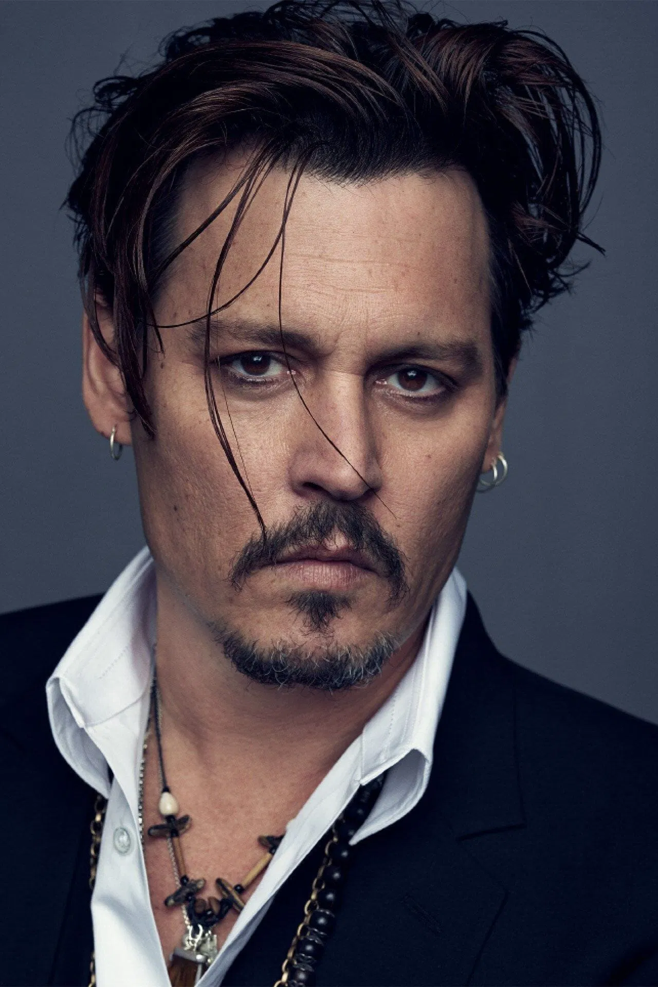 Cinematic studio portrait of Johnny Depp, wearing a dark velvet suit with subtle bohemian silver rings, holding a luxury Valentino perfume bottle, dark moody background, high-end fashion magazine editorial style, dramatic lighting, sharp focus, 8k resolution, photorealistic, shot on 85mm lens, f/1.8 --ar 3:4